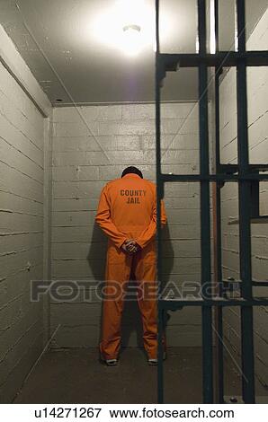 Stock Photo - Prisoner standing against the wall. Fotosearch