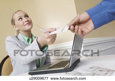 Stock Photo - Receptionist distributing name tags. Fotosearch