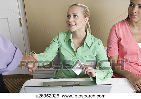 Stock Photograph - Receptionist distributing name tags. Fotosearch