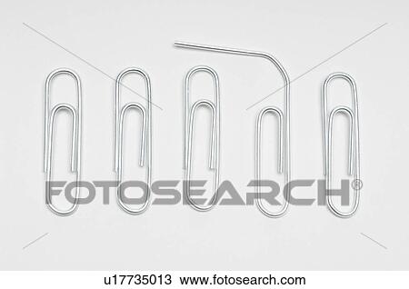 Stock Image - Row of paper clips with one bent. Fotosearch