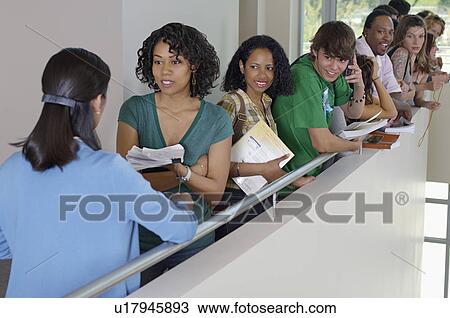 Stock Image - Row of students and teacher standing on balcony in school. Fotosearch