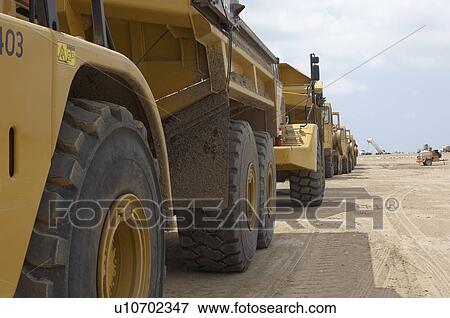 Row of trucks at landfill site View Large Photo Image Stock Photo - Row of trucks at landfill site. Fotosearch