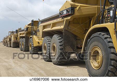 Row of trucks at landfill site View Large Photo Image Stock Photograph - Row of trucks at landfill site. Fotosearch