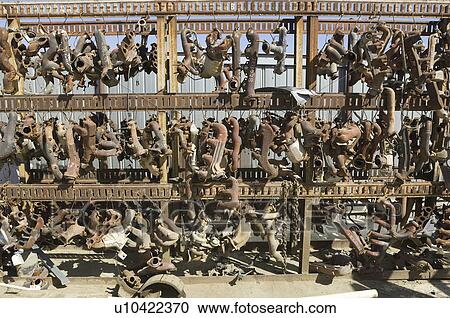 Stock Image - Rusty car parts on rack. Fotosearch