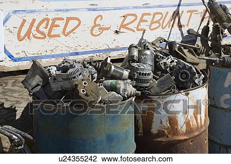 Stock Image - Rusty sign and barrels in junkyard. Fotosearch