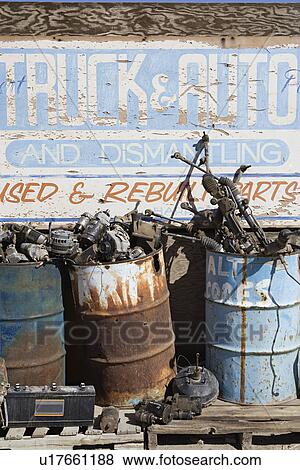 Stock Photo - Rusty sign and barrels in junkyard. Fotosearch