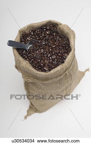 Picture - Sack of coffee beans with spoon. Fotosearch