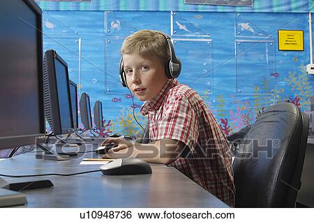 School boy wearing headphones in computer room View Large Photo Image Stock Photograph - School boy wearing headphones in computer room. Fotosearch