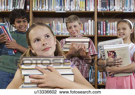 School children holding books in library View Large Photo Image Stock Image - School children holding books in library. Fotosearch