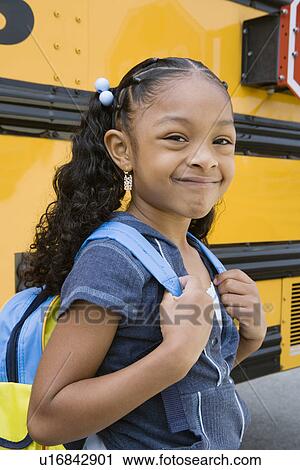 Stock Image - School Girl by School Bus. Fotosearch