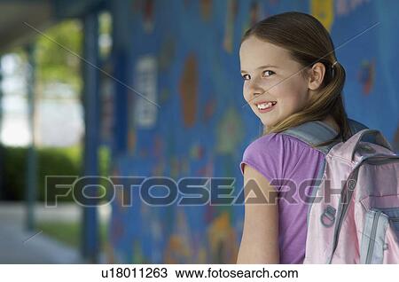 Stock Image - School girl outside school. Fotosearch
