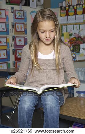 School girl reading book on desk in classroom View Large Photo Image Stock Photo - School girl reading book on desk in classroom. Fotosearch