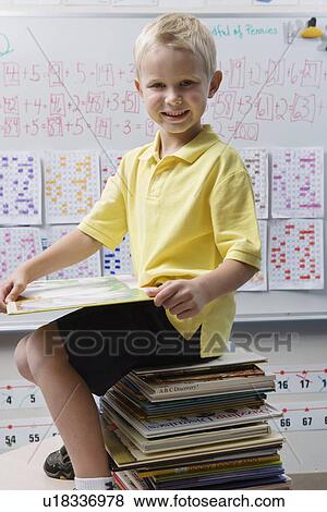 Schoolboy Sitting on a Stack of Books View Large Photo Image Stock Photo - Schoolboy Sitting on a Stack of Books. Fotosearch
