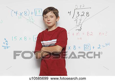 Stock Photo - Schoolboy standing against whiteboard. Fotosearch