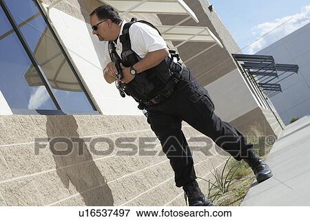 Stock Photo - Security guard with gun patrolling. Fotosearch