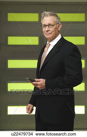Picture - Senior Businessman Holding PDA. Fotosearch