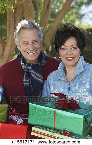 Senior couple carrying presents outside, portrait View Large Photo Image Stock Image - Senior couple carrying presents outside, portrait. Fotosearch