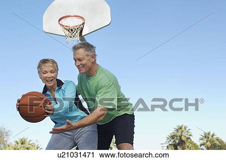 Senior couple playing basketball on outdoor court View Large Photo Image Stock Image - Senior couple playing basketball on outdoor court. Fotosearch