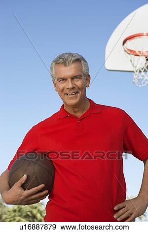 Senior man on outdoor basketball court, portrait View Large Photo Image Stock Photo - Senior man on outdoor basketball court, portrait. Fotosearch