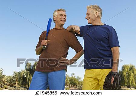 Senior man with baseball mitt leaning on man with baseball bat, outdoors View Large Photo Image Stock Photography - Senior man with baseball mitt leaning on man with baseball bat, outdoors. Fotosearch