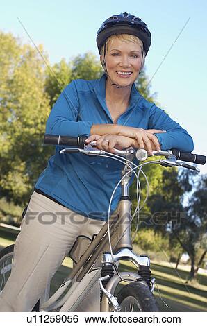 Senior woman leaning on bicycle, portrait View Large Photo Image Stock Photograph - Senior woman leaning on bicycle, portrait. Fotosearch