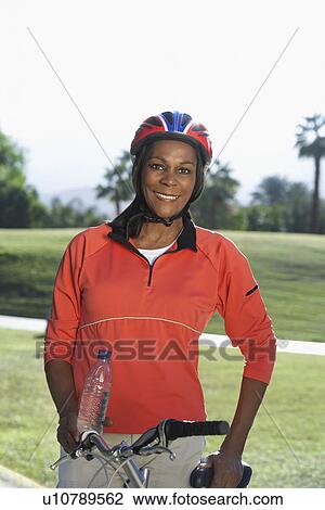 Senior woman on bicycle in park, portrait View Large Photo Image Stock Image - Senior woman on bicycle in park, portrait. Fotosearch