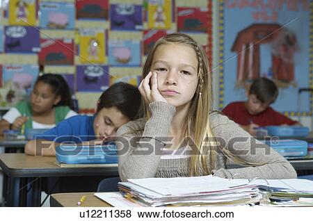 Stock Photo - Serious schoolgirl sitting and leaning. Fotosearch