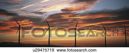 Stock Photo - Silhouettes of wind turbines at sunset. Fotosearch