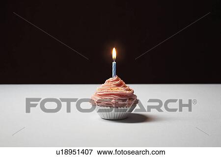 Stock Photo - Single cupcake with birthday candle. Fotosearch
