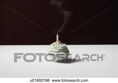 Stock Photo - Single cupcake with blown out birthday candle. Fotosearch