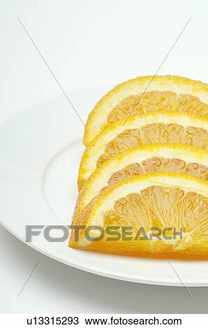 Stock Image - Sliced orange on plate, close-up. Fotosearch