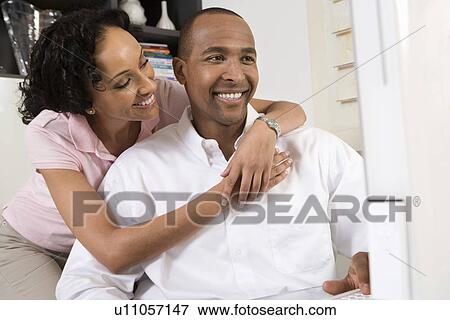 Stock Photo - Smiling Couple Using a Computer. Fotosearch