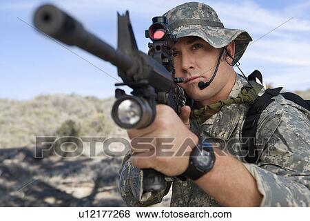 Stock Photo - Soldier aiming machine gun, close-up. Fotosearch
