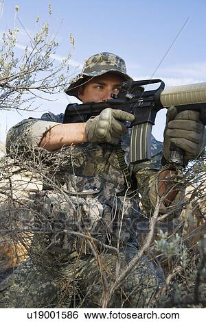 Stock Photograph - Soldier aiming machine gun, close-up. Fotosearch