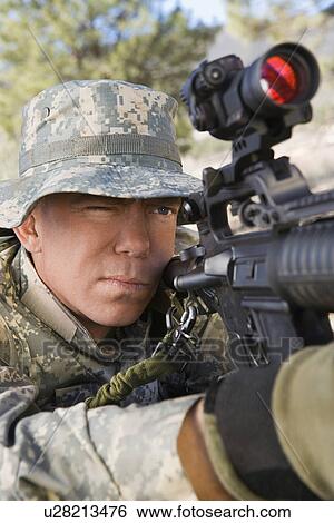 Stock Photograph - Soldier aiming machine gun, close-up. Fotosearch