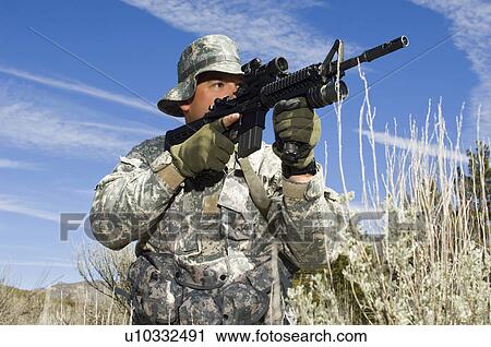 Stock Image - Soldier aiming machine gun. Fotosearch
