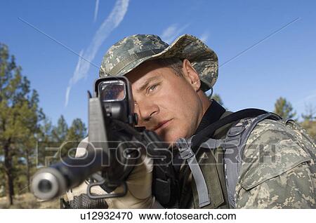Stock Image - Soldier aiming machine guns, close-up. Fotosearch