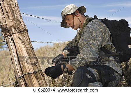 Soldier cutting barbed wire fence View Large Photo Image Picture - Soldier cutting barbed wire fence. Fotosearch