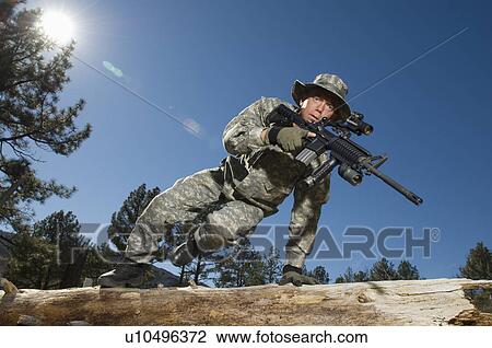 Stock Image - Soldier jumping over log. Fotosearch