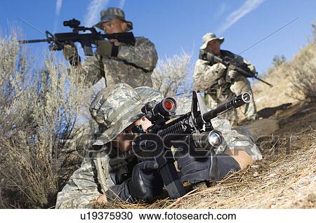 Stock Image - Soldiers aiming machine guns. Fotosearch