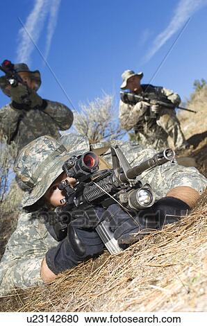 Stock Image - Soldiers aiming machine guns. Fotosearch