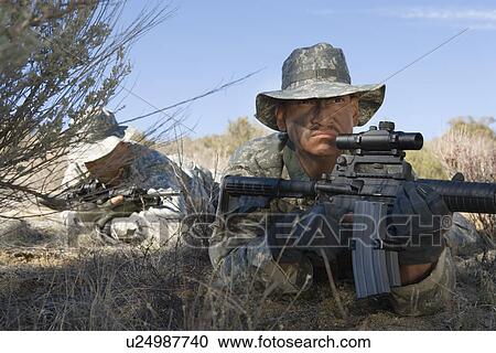 Soldiers aiming rifles in field, focus on soldier in foreground View Large Photo Image Stock Image - Soldiers aiming rifles in field, focus on soldier in foreground. Fotosearch