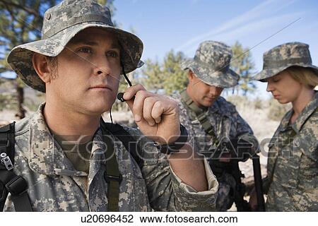 Stock Image - Soldiers in field, focus on one in foreground. Fotosearch