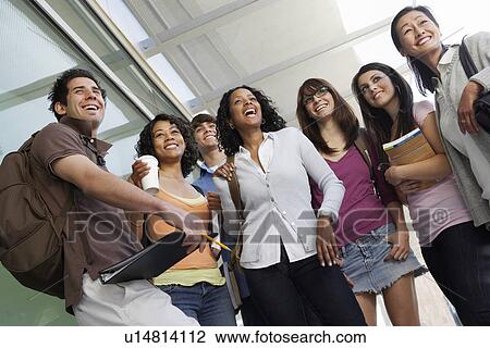 Stock Image - Students smiling in hallway at school, low angle view. Fotosearch