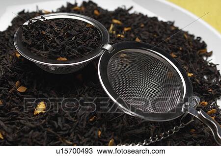 Stock Image - Tea strainer on heap of tea leaves. Fotosearch