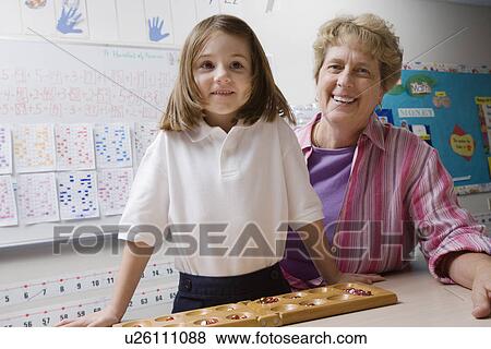 Stock Photo - Teacher and Schoolgirl with Counting Tray. Fotosearch