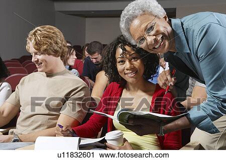 Teacher bending to couple of college students View Large Photo Image Stock Image - Teacher bending to couple of college students. Fotosearch