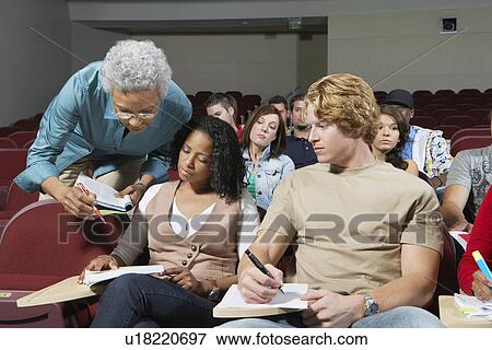 Stock Photo - Teacher bending to couple of college students. Fotosearch