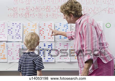 Stock Photo - Teacher Explaining Calendar to Little Boy. Fotosearch