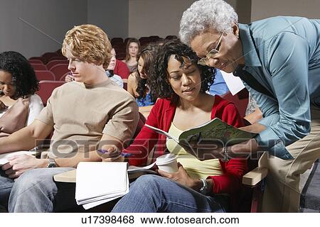 Stock Photo - Teacher explaining something to female college student. Fotosearch